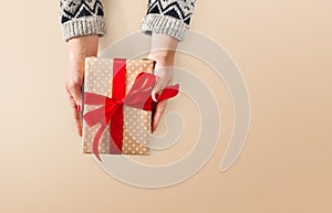 Woman`s hands give christmas gift in present box