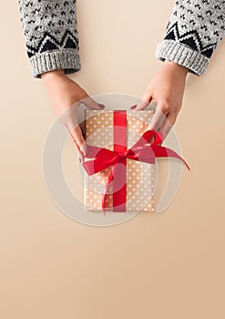 Woman`s hands give christmas gift in present box