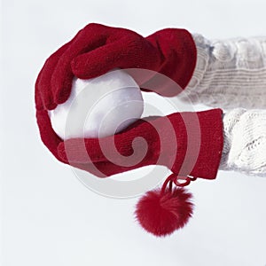 Woman`s hands with gloves holding snowball. People having fun playing in the snow outdoors in winter