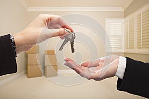 Woman's Hands Handing Over the House Keys Inside Empty Tan Room