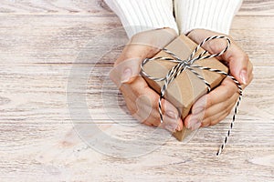 Woman's hands hold christmas or new year decorated gift box