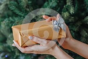 Woman`s hands hold christmas or new year decorated gift box