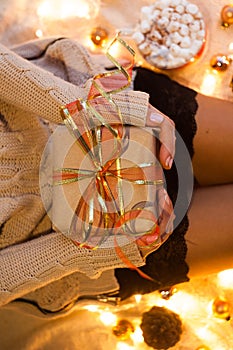 Woman`s hands hold christmas or new year decorated gift box. New Year`s concept.selective focus