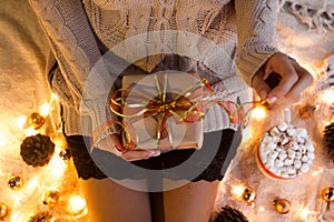 Woman`s hands hold christmas or new year decorated gift box. New Year`s concept.selective focus