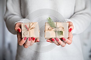 Woman`s hands hold christmas or new year decorated gift box. Ton