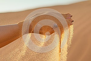 A woman`s hands hold desert sand photo