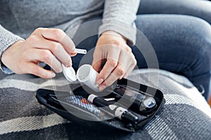 Woman`s hands hold package with strips for glucometer