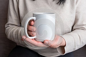 Woman's hands hold a pristine white mug, providing a perfect canvas