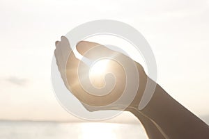 Woman`s hands hold the sun and its energy