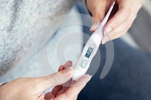 Woman`s hands hold thermometer