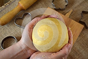 Woman`s hands are holding ball-shaped dough