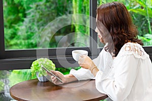 Woman`s hands holding black mobile phone