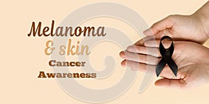 The woman & x27;s hands are holding black Ribbon for symbol Melanoma and skin cancer. Narcolepsy, Primary Biliary