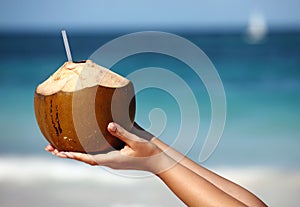 Woman`s hands holding coconut photo