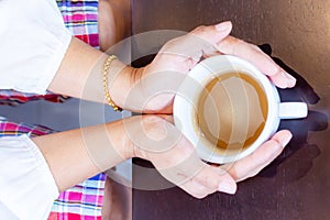 Woman`s hands holding coffee cup