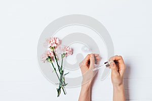 Woman's hands holding eyedropper applying cosmetic serum