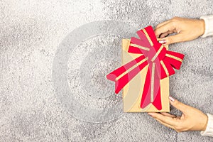 Woman`s hands holding gift box on the table.- Christmas and New Year concept.