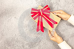 Woman`s hands holding gift box on the table.- Christmas and New Year concept.