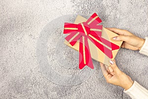 Woman`s hands holding gift box on the table.- Christmas and New Year concept.