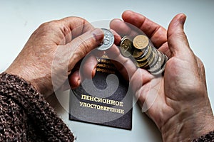 Woman`s hands holding russian coins over the pension certificate.