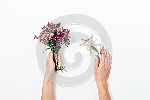 Woman`s hands holding small bouquet and tiny gift box