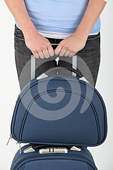 Woman's hands holding a suitcase