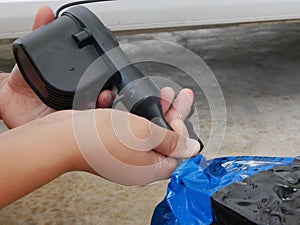 A woman`s hands holding and using mini air pump, connected to the car plug, to inflate a rocking doll