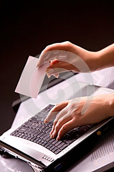 Woman's hands with keybord and business card