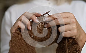 Woman& x27;s hands knitting wool yarn pattern.