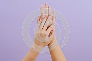 Woman's hands on lilac background. Skin care for hands, manicure and beauty treatment