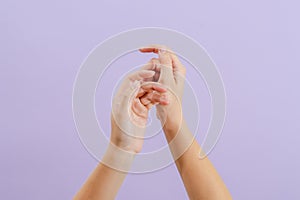 Woman's hands on lilac background. Skin care for hands, manicure and beauty treatment