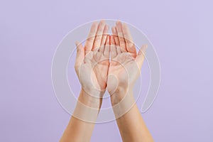 Woman's hands on lilac background. Skin care for hands, manicure and beauty treatment