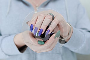 Woman\'s hands with long nails and multi-colored manicure