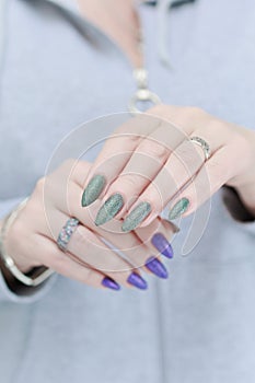 Woman\'s hands with long nails and multi-colored manicure