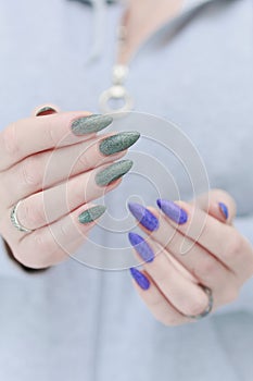 Woman\'s hands with long nails and multi-colored manicure