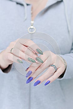 Woman\'s hands with long nails and multi-colored manicure