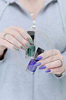 Woman\'s hands with long nails and multi-colored manicure