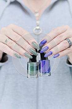 Woman\'s hands with long nails and multi-colored manicure