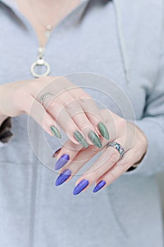 Woman\'s hands with long nails and multi-colored manicure