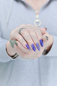 Woman\'s hands with long nails and multi-colored manicure