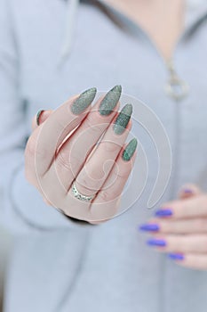 Woman\'s hands with long nails and multi-colored manicure