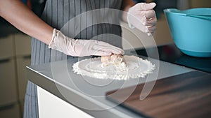 Woman`s hands making minced steak cutlets or meat balls of forcemeat. Pouring out cutlets in flour