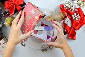 Woman's hands making a pregnancy test as a Christmas gift. table with decorations. View from above. Holiday mood, motherhood