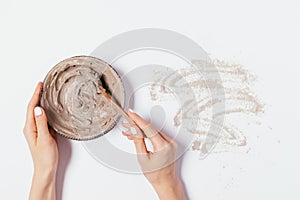 Woman's hands mix homemade clay face mask