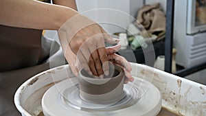 Woman`s hands moulding clay, making a clay pottery pot in the handicraft workshop