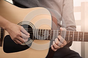 Woman`s hands playing acoustic guitar.