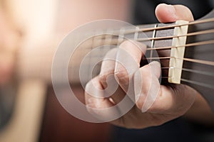 Woman`s hands playing acoustic guitar.