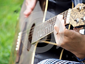 Woman`s hands playing acoustic guitar