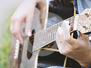 Woman`s hands playing acoustic guitar