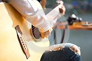 Woman`s hands playing acoustic guitar,